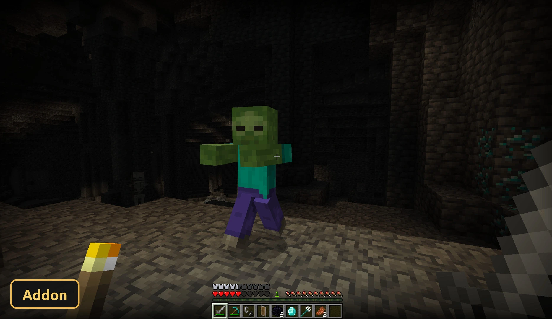 player holding a torch in a dark cave with a zombie