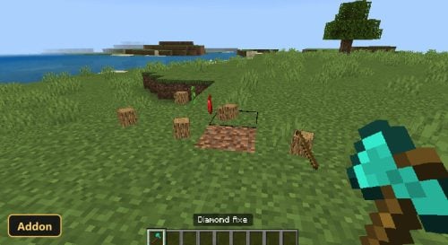 a diamond axe and a chopped tree with logs on the ground